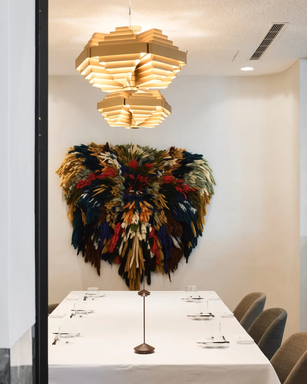 Private box met gedekte tafel en verenkunstwerk